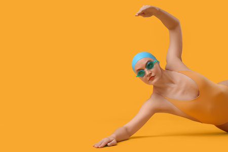 Female swimmer on yellow backgroundの写真素材