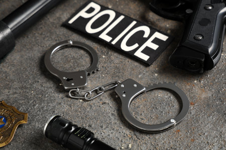 Word POLICE, handcuffs and weapon on gray background, closeupの写真素材