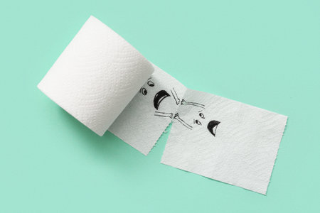 Toilet paper roll with drawn funny faces on color background. Friendship Day celebration