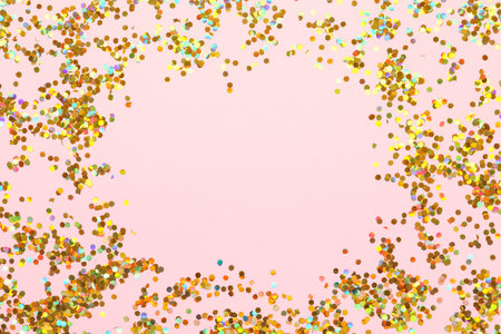 Frame made of beautiful golden confetti on pink backgroundの写真素材