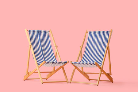 Striped deck chairs on pink background