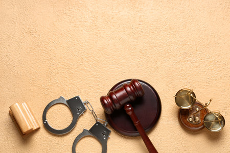 Judge's gavel, scales of justice, handcuffs and stamp on beige backgroundの写真素材
