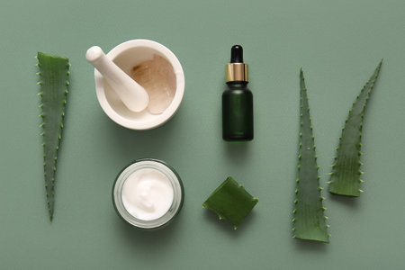 Different cosmetic products with aloe vera leaves on green backgroundの写真素材
