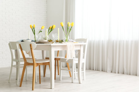 Elegant table setting with beautiful tulip flowers and candles in light dining roomの写真素材