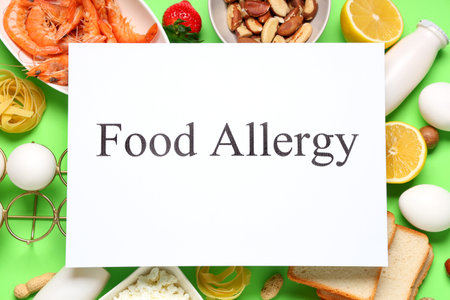 Paper with text FOOD ALLERGY and different products on green backgroundの写真素材