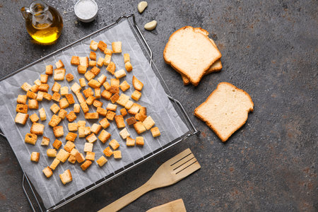Baking rack with crunchy croutons and garlic on dark backgroundの写真素材