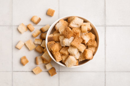 Bowl with crunchy croutons on white tile backgroundの写真素材
