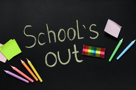 Composition with different stationery and text SCHOOL'S OUT on dark backgroundの写真素材