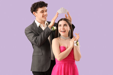 Young boy crowning his prom date on lilac backgroundの写真素材