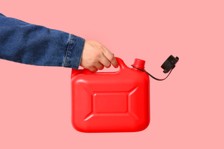 Male hand holding canister on pink backgroundの写真素材