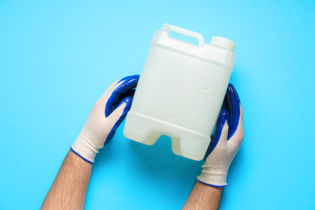 Male hands holding canister on blue backgroundの写真素材