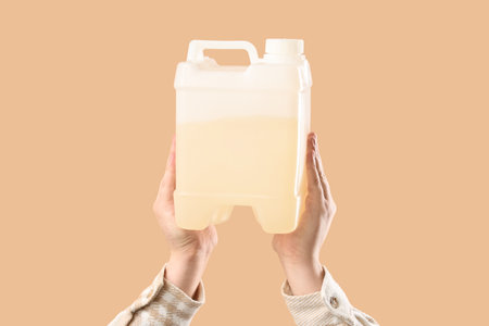 Female hands holding canister on beige backgroundの写真素材