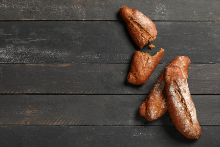 Fresh rye baguettes on black wooden backgroundの写真素材