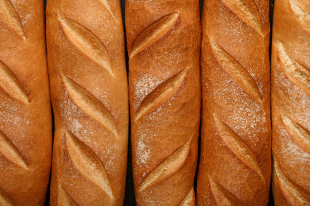 Many fresh baguettes on black background, closeupの写真素材