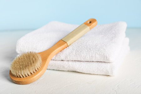 Clean towels and massage brush on light tableの写真素材