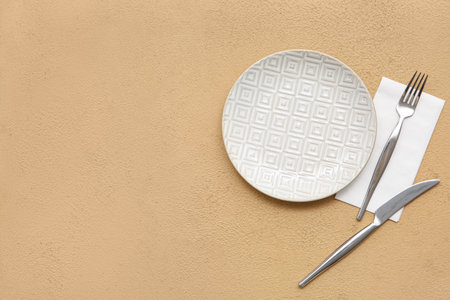 Plate with cutlery and paper napkin on yellow grunge backgroundの写真素材