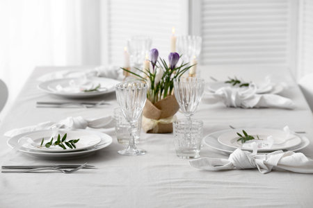Table setting for Mother's Day celebration with beautiful flowers and burning candles in dining room