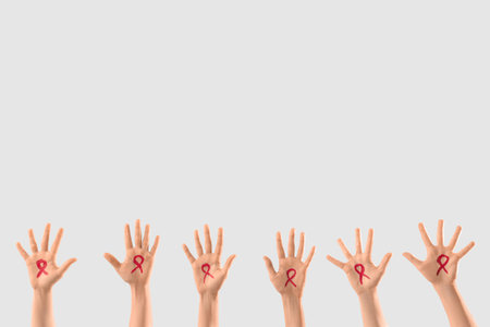 Female hands with drawn red ribbons on light background. Blood cancer awareness conceptの写真素材