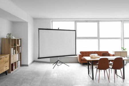 Interior of conference hall with projector screen, sofa and table