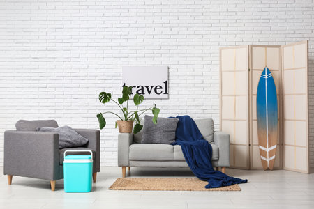 Interior of stylish living room with gray sofa, armchair and summer decorの写真素材