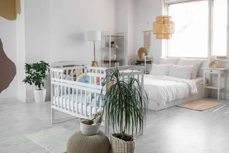 Interior of light bedroom with baby crib, shelf units and toysの写真素材