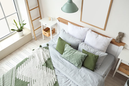 Interior of light bedroom with cozy bed, big window and houseplantの写真素材