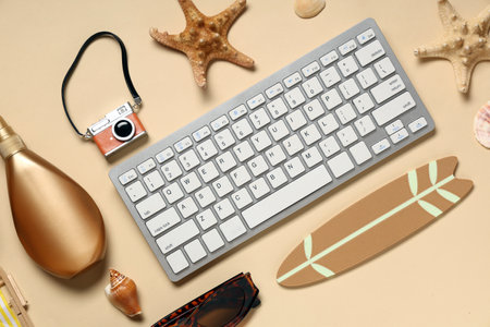 Computer keyboard with camera and beach decor on beige backgroundの写真素材