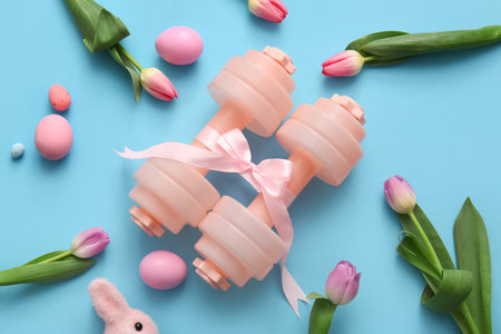 Composition with dumbbells, tulip flowers and Easter eggs on color backgroundの写真素材