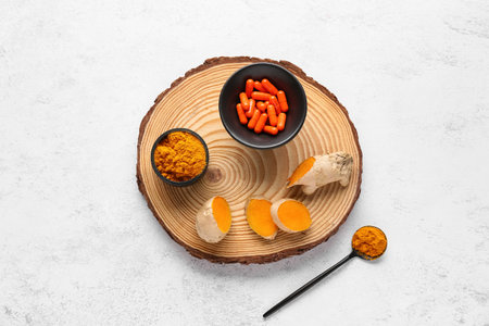 Composition with turmeric powder and pills on white background, top view
