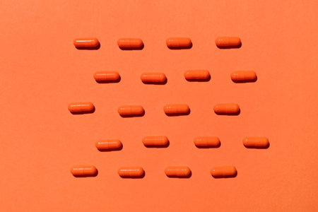 Many turmeric pills on orange backgroundの写真素材