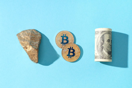 Bitcoins, golden nugget and dollar banknote on blue background