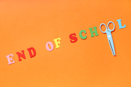 Text END OF SCHOOL made of colorful letters and scissors on orange backgroundの写真素材