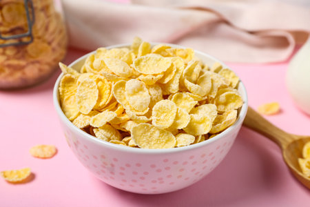 Bowl with delicious cornflakes on pink background, closeupの写真素材