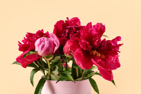 Gift box with beautiful peony flowers on yellow backgroundの写真素材