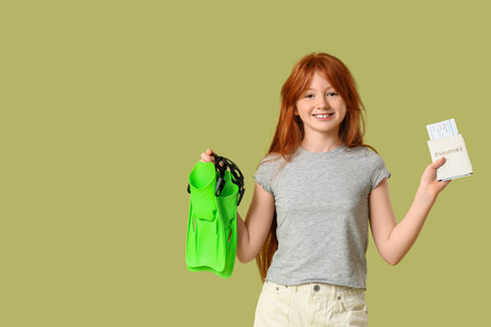Cute girl with flippers and passport on green background. Travel conceptの写真素材