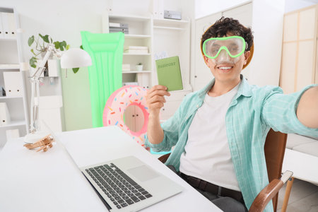 Young businessman with snorkeling mask waiting for summer vacation in office