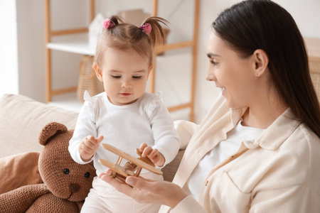 Mother with toy plane and her baby playing at homeの写真素材