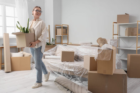 Young woman with box in room on moving day