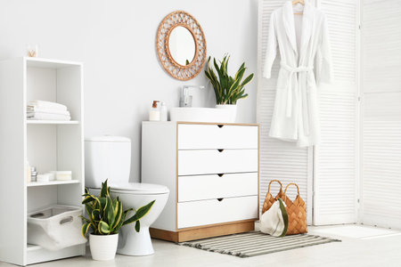 Interior of restroom with toilet bowl, sink and Sansevieria plants