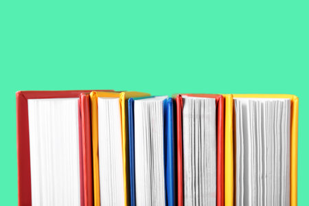 Row of colorful books on green backgroundの写真素材