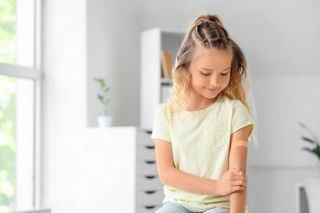 Little girl with patch applied after vaccination in clinicの写真素材
