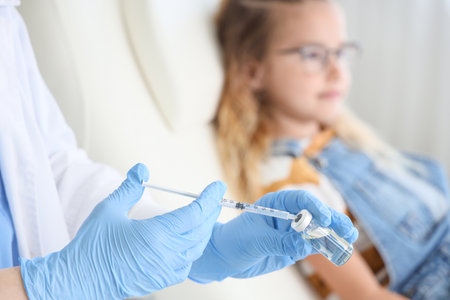 Doctor with vaccine and little girl in clinic, closeupの写真素材
