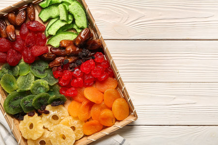 Wicker tray with different candied fruits on white wooden backgroundの写真素材