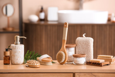 Set of spa accessories with different massage brushes on wooden table in bathroomの写真素材