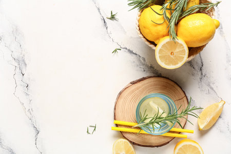 Glass of fresh lemonade with rosemary and lemons on white backgroundの写真素材