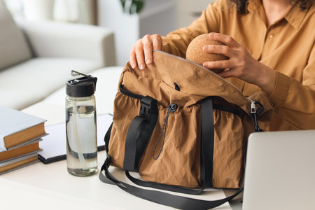 Mature businesswoman putting massage ball into sports bag at table in office, closeupの写真素材