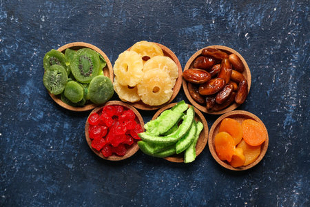 Bowls with different candied fruits on blue backgroundの写真素材