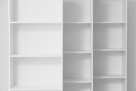 Empty bookshelf near light wallの写真素材