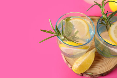 Glasses of fresh lemonade with rosemary on pink background, closeupの写真素材
