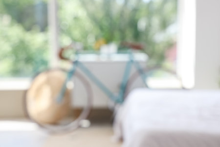Blurred view of bicycle near chest of drawers in bedroomの写真素材